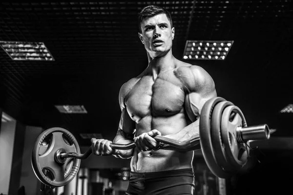 Bonito modelo jovem treinamento braços no ginásio — Fotografia de Stock