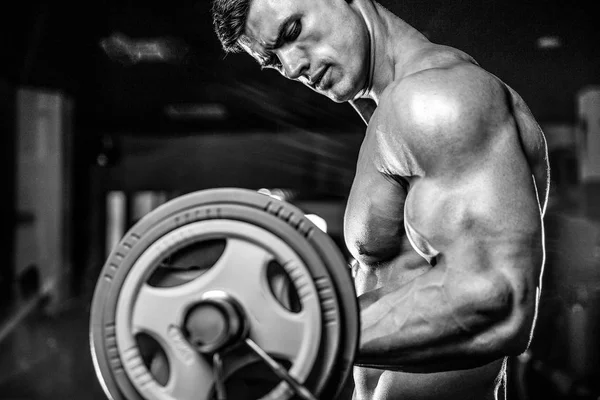 Bonito modelo jovem treinamento braços no ginásio — Fotografia de Stock