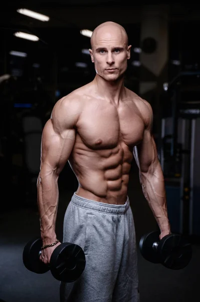 Brutalt starka bodybuilder atletiska män pumpa upp muskler med d — Stockfoto