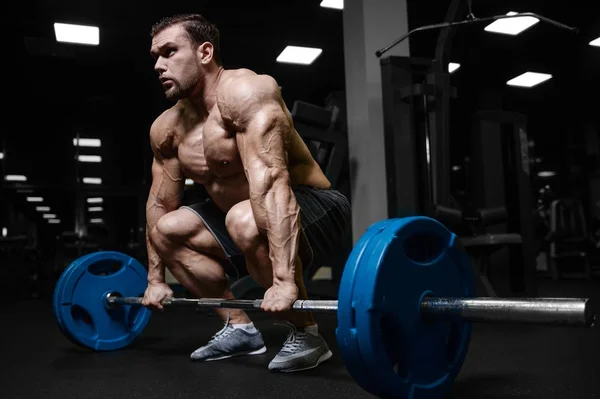 Brutalt starka bodybuilder atletiska män pumpa upp muskler med d — Stockfoto