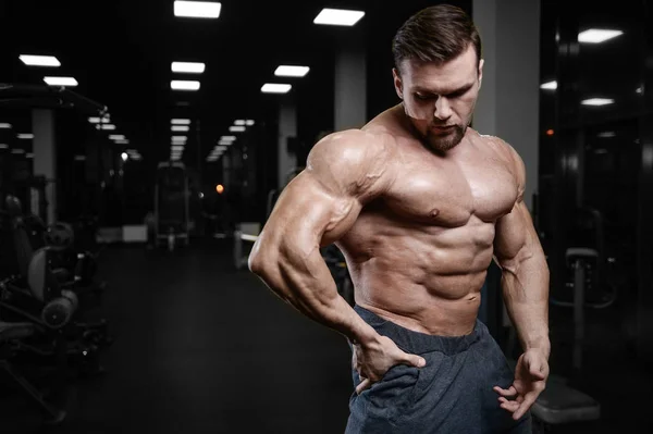 Brutale forte bodybuilder uomini atletici pompaggio muscoli con d — Foto Stock