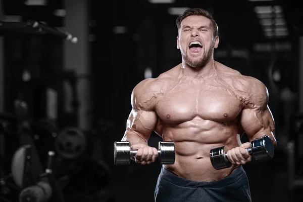 Brutal strong bodybuilder athletic men pumping up muscles with d — Stock Photo, Image