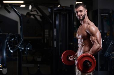 seksi güçlü vücut geliştirmeci atletik erkek dum ile kasları kadar pompalama