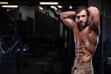 seksi güçlü vücut geliştirmeci atletik erkek dum ile kasları kadar pompalama