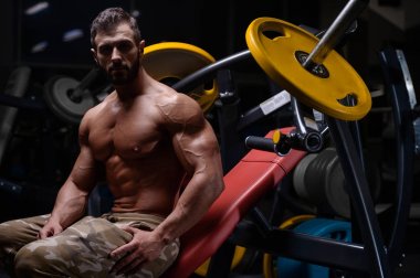 seksi güçlü vücut geliştirmeci atletik erkek dum ile kasları kadar pompalama