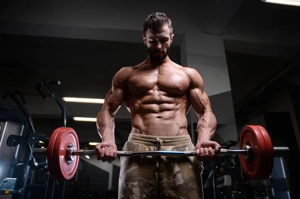 Sexy strong bodybuilder athletic men pumping up muscles with dum — Stock Photo, Image