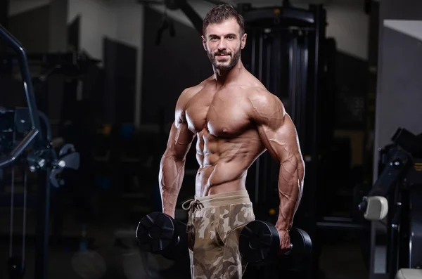 Sexy strong bodybuilder athletic men pumping up muscles with dum — Stock Photo, Image