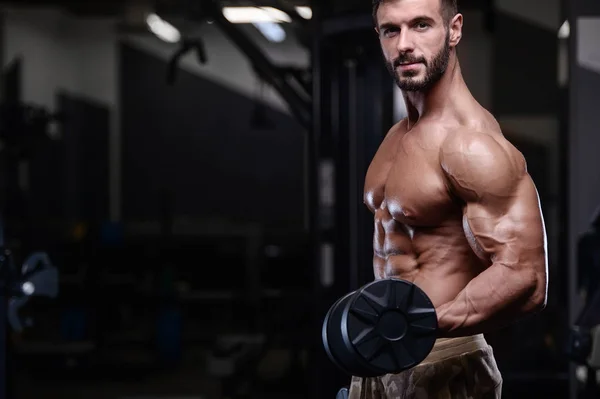 Sexy fort bodybuilder athlétisme hommes pompage les muscles avec dum — Photo