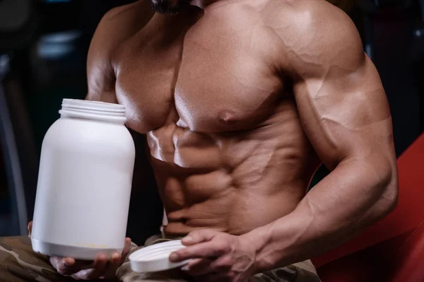 Sexy strong bodybuilder athletic men pumping up muscles with dum — Stock Photo, Image