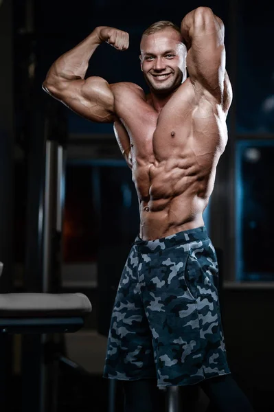 Brutal strong bodybuilder athletic men pumping up muscles with d — Stock Photo, Image