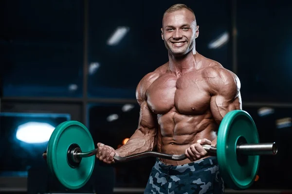 Brutal strong bodybuilder athletic men pumping up muscles with d — Stock Photo, Image