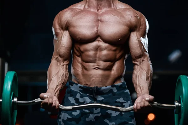 Brutális erős testépítő sportos férfi szivattyúzás fel izmokat, d — Stock Fotó
