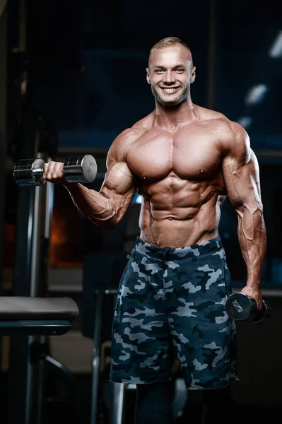 Brutal strong bodybuilder athletic men pumping up muscles with d — Stock Photo, Image