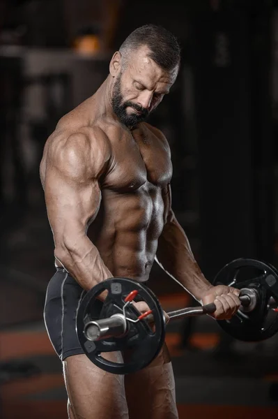 Gamle brutale stærk bodybuilder atletiske mænd pumpe op muskler wi - Stock-foto