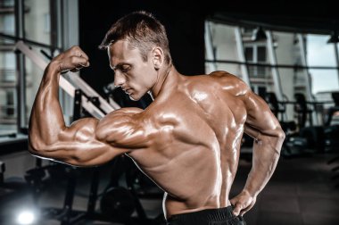 Yakışıklı model genç adam spor salonunda egzersiz
