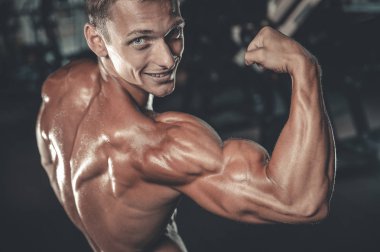 Yakışıklı model genç adam eğitim kollarında spor salonu