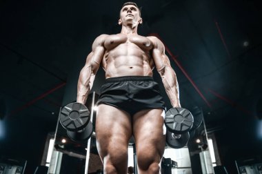 Yakışıklı model genç adam spor salonunda egzersiz