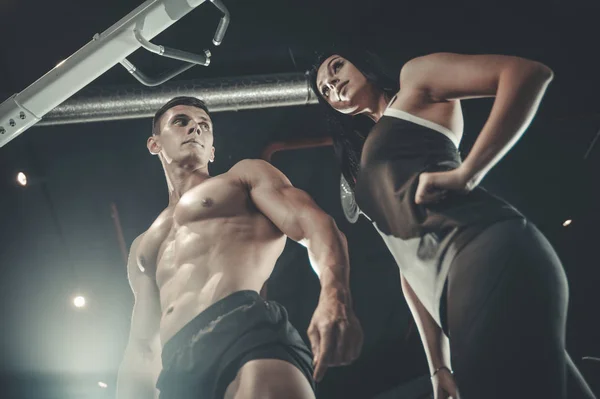 Modelo joven hombre y mujer haciendo ejercicio en gy — Foto de Stock