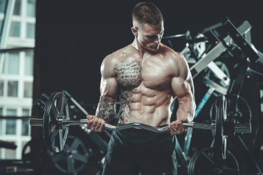 Yakışıklı model genç adam spor salonunda egzersiz