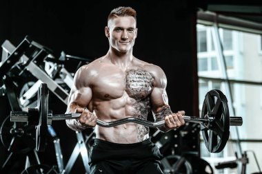 Yakışıklı model genç adam spor salonunda egzersiz