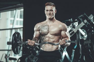 Yakışıklı model genç adam spor salonunda egzersiz
