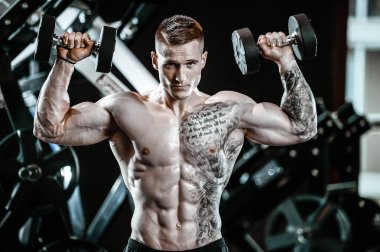 Yakışıklı model genç adam spor salonunda egzersiz