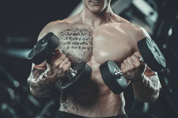 Guapo modelo joven que trabaja en el gimnasio — Foto de Stock