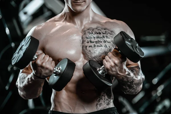 Guapo modelo joven que trabaja en el gimnasio — Foto de Stock