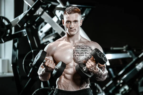 Gut aussehend modell junger mann training arms im fitnessstudio — Stockfoto