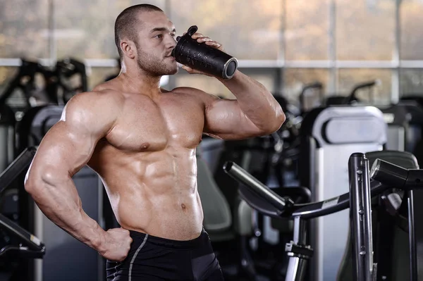 Brutal strong bodybuilder athletic men pumping up muscles with d — Stock Photo, Image