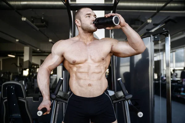 Brutal strong bodybuilder athletic men pumping up muscles with d — Stock Photo, Image