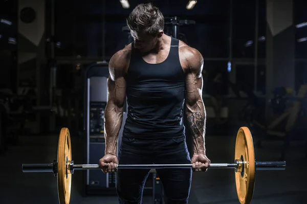 Guapo modelo joven entrenamiento en el gimnasio —  Fotos de Stock