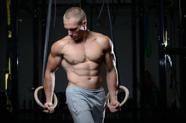 Yakışıklı adam atlet jimnastik yüzüklere eğitim