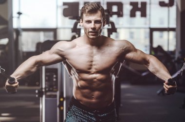 yakışıklı güçlü vücut geliştirmeci atletik erkek ile kasları kadar pompalama