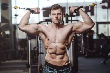 yakışıklı güçlü vücut geliştirmeci atletik erkek ile kasları kadar pompalama