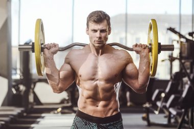 yakışıklı güçlü vücut geliştirmeci atletik erkek ile kasları kadar pompalama