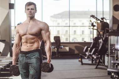 yakışıklı güçlü vücut geliştirmeci atletik erkek ile kasları kadar pompalama