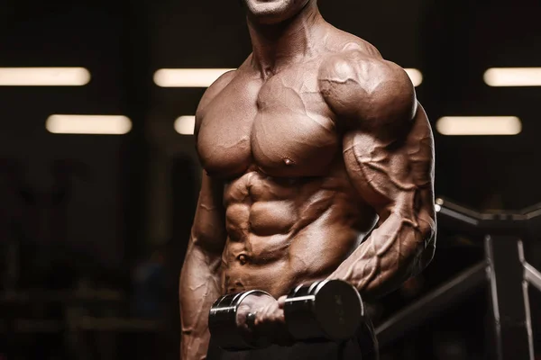 Schöner starker athletischer Mann, der die Bizeps-Muskeln hochpumpt — Stockfoto