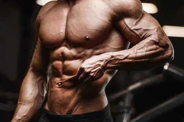 Guapo hombre atlético fuerte bombeo músculos entrenamiento fitness —  Fotos de Stock