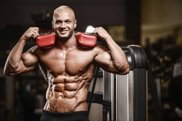 Bonito homem atlético forte bombeando músculos treino fitness — Fotografia de Stock