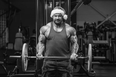 Spor salonunda Noel Baba kostümlü vücut geliştirici.