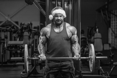 Spor salonunda Noel Baba kostümlü vücut geliştirici.