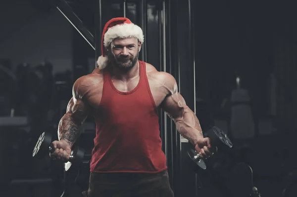 Culturista disfrazado de Papá Noel en el gimnasio — Foto de Stock