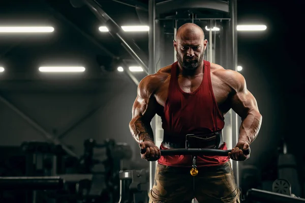 Vücut geliştirici yakışıklı güçlü atletik adam bisepsi pompalıyor. — Stok fotoğraf