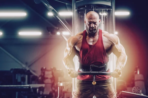 Vücut geliştirici yakışıklı güçlü atletik adam bisepsi pompalıyor. — Stok fotoğraf