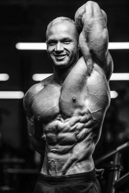 Yakışıklı, güçlü atletik adam kaslarını çalıştırıyor. 