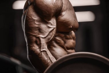 Yakışıklı, güçlü atletik adam kaslarını şişiriyor.