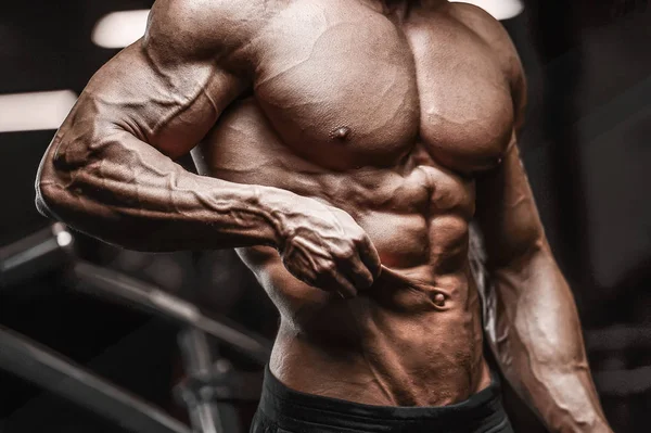 Красивый сильный спортсмен накачивает мышцы тренировки фитнеса — стоковое фото