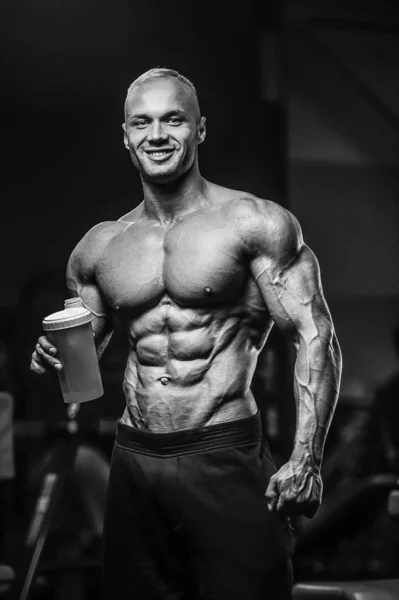 Sport muscular fitness man drinking water after workout cross fi