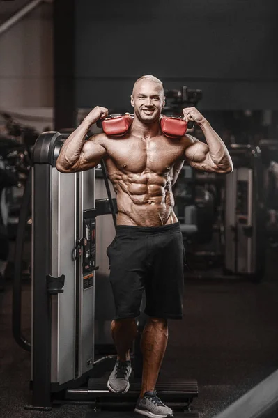 Bonito homem atlético forte bombeando músculos treino fitness — Fotografia de Stock